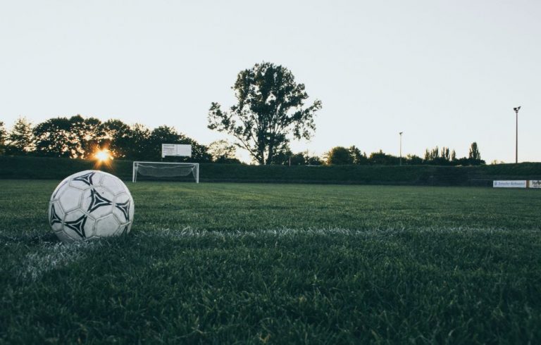 A close up shot of a football in front of a goal.